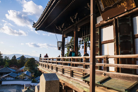 Tourist people at Todai-ji Nigatsudo temple balcony to view  aerial cityscape in autumn, Nara, Japan. Famous travel destination for tour in Kansai to see deer at peak fall in December.の写真素材