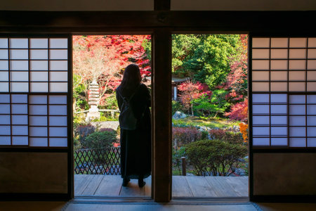 Tourist woman on balcony view beautfiul autumn garden with colorful maple leaves, Kyoto, Japan....