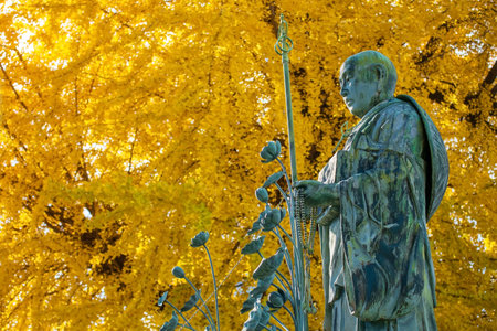 KoboDaishi Buddhist monk statue by Ginkgo yellow leaves at autumn in Shitennoji Temple Osaka, Japan. Famous travel destination for sightseeing Kansai in fall season.の写真素材