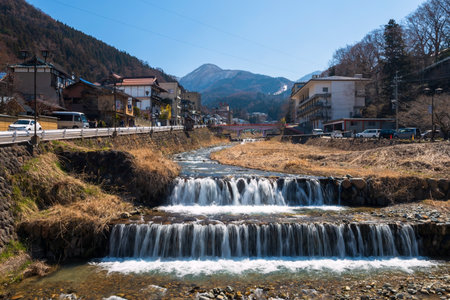 Yamanouchi, Japan - April 13, 2019: Shibu Onsen hot springs town and Yokoyu river against blue sky, Nagano. The town is famous for hot springs and Jigokudani monkey snow park.の写真素材