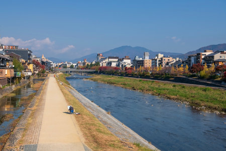 Japanese painter draw view of Autumn colors on promenade along Kamo River next to Shijo Bridge in Gion District, Kyoto, Japan.の写真素材