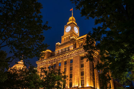 China century old clock tower of the Bund by Huangpu River at night, Shanghai, China. Famous travel...