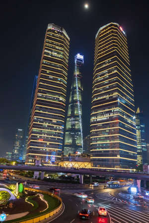Shanghai, China - April 10, 2025:Lujiazui Circular Pedestrian Bridge with modern tower light up and...