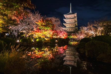 Toji temple 5 story pagoda and colorful autumn leaf light up with skyline reflection on pond at...