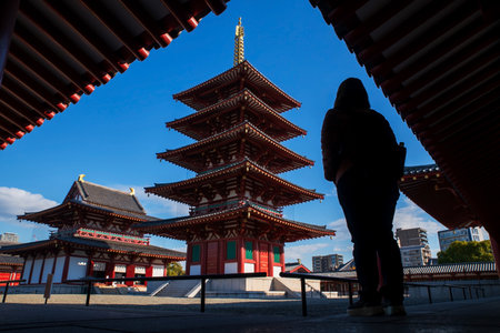 Silhouette Japanese woman view 5 Storied Pagoda of Shitennoji Temple against blue sky, Osaka, Japan. Famous travel destination for sightseeing Kansai in fall season.の写真素材