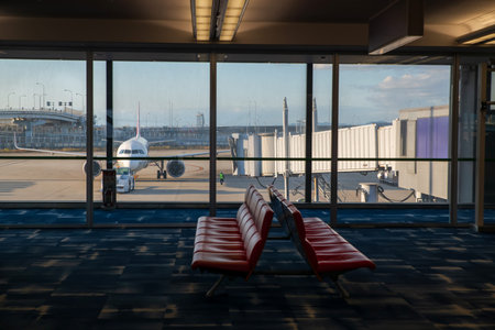 Waiting seats at departure terminal with airplane in runway at International Airport. Aircraft wait...