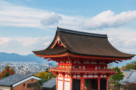 Kiyomizudera temple Sammon gate against city and blue sky in autumn, Kyoto, Japan. Vibrant orange pagoda stands out with colorful foliage enhancing the scenic beauty.の写真素材