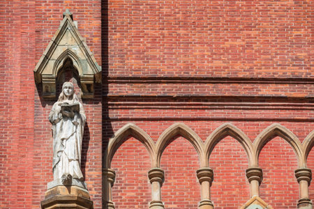 Virgin Mary Statue reading bible book on facade building of St. Ignatius Xujiahui Cathedral,...