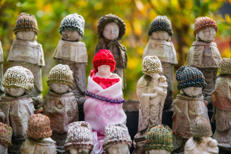 Jizu statues in red knit hat and necklace bead at Hase-dera or Hasedera temple in autumn, Sakurai,...