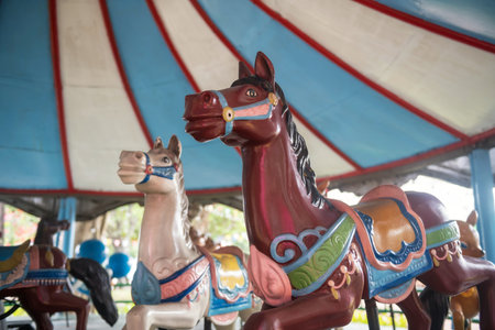 Old Merry-go-round horses in amusement park. carousel in funfairの写真素材