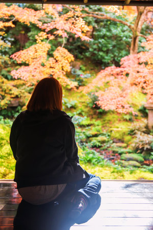 Rear woman in Rurikoin temple terrace view zen garden with autumn leaf colors, Kyoto, Japan. travel destination for tourist sightseeing Kansai for fall season.の写真素材