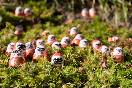 Many small daruma figure decor on green plant in Katsuo-ji temple garden, Minoh, Osaka, Japan....