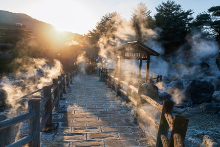 Silhouette people at mount Unzen Hell valley Jigoku and hot springs at sunset with gas steam by Shimabara city, Nagasaki, Kyushu, Japan. Hot water, gases and steam spout out of the earth.の写真素材
