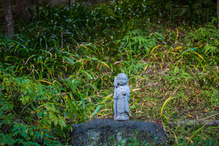 Jizo Buddist statue on rock at garden of Nisonin temple, Arashiyama, Kyoto, Japan. Famous travel destination for tourist sightseeing garden of Kansai in fall season.の写真素材