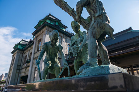 Kitakyushu, Japan - October 11, 2025: Statue in front of Mojiko retro station depicts the image of workers against blue skyの写真素材
