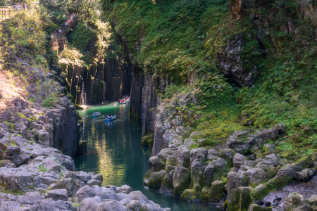 Tourist people sailing rowboat over blue water of Takachiho gorge, Nishiusuki, Miyazaki, Kyushu, Japan. Famous travel destination of volcanic gorge to view Nature Scenery.の写真素材