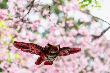 Red frog with wings hang on tree with pink cherry sakura blossom at Nyoirinji Temple, Ogori, Fukuoka, Japan. destination for toad figurine known as Kaeru dera, while formal name is Seieizan Nyoirin-jiの写真素材