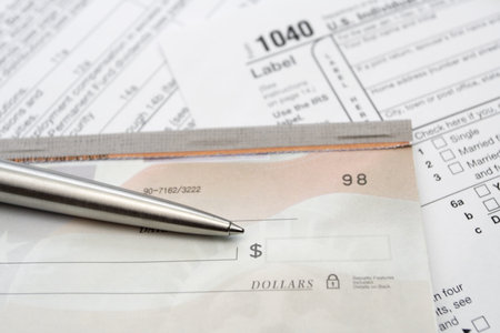 Checkbook and 1040 tax form with pen