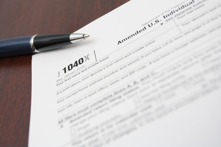 1040X tax form and pen on brown table