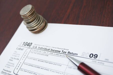 1040 tax form, pen and coin as a financial conceptの写真素材