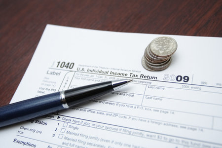 1040 tax form, pen and coins as a finance concept