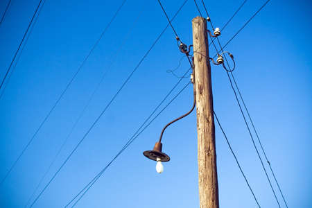 Electrical wooden pylon, cables, wires and blue skyの写真素材