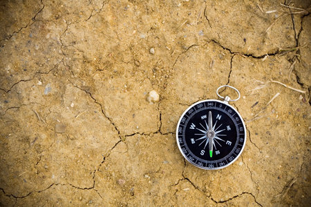 Compass and navigation background on dry sandの写真素材