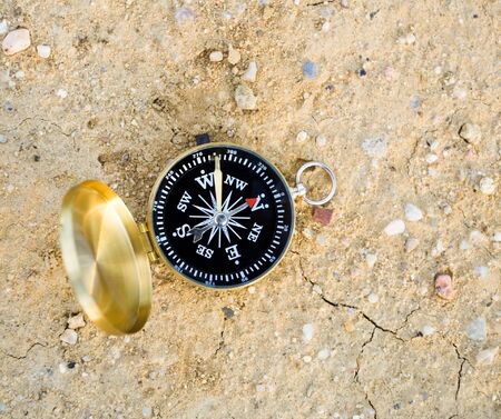 Compass and navigation background on dry sandの写真素材
