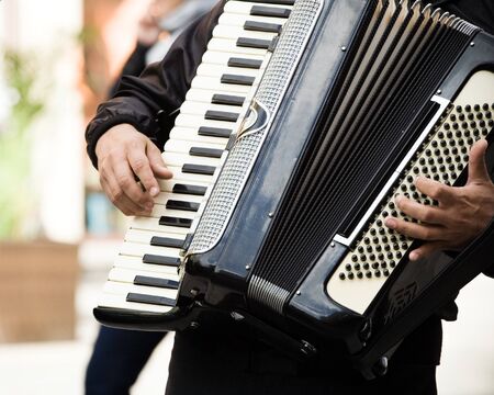 Musician playing on accordion on city streetの写真素材