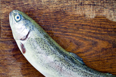 Preparing rainbow trout on wooden plateの写真素材