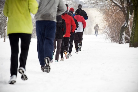 People running in park on snowy winterの写真素材