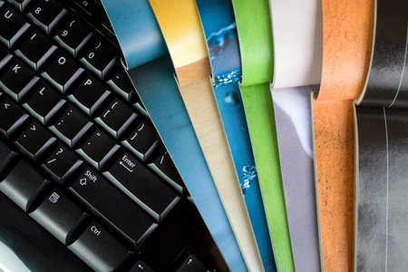 Open magazines and computer keyboard, new media and technologyの写真素材