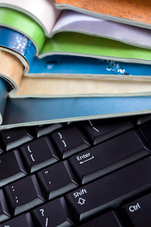 Open magazines and computer keyboard, new media and technologyの写真素材