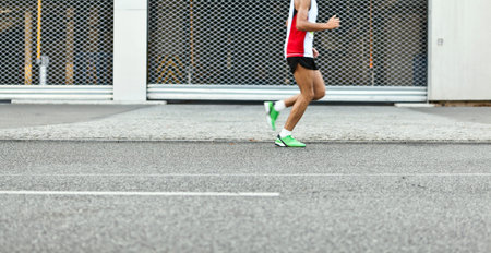 Man running in marathon on city street, motion blur