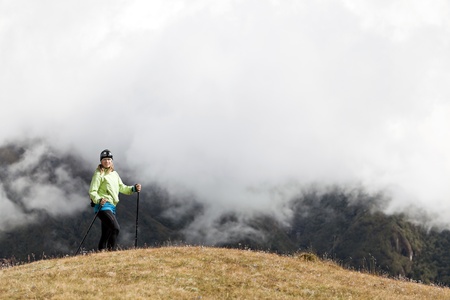 Young woman hiker hiking in Himalaya Mountains in Nepal. Trekking and nordic walking, exercising outdoors.の写真素材