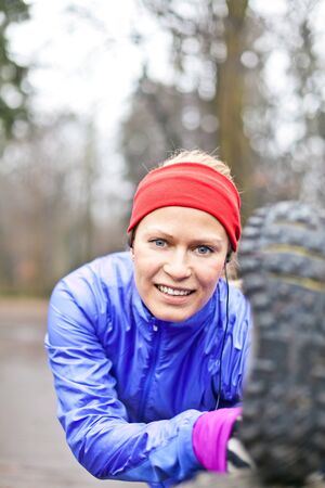 Woman runner stretching and exercising in winter forestの写真素材