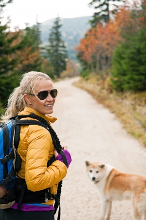 Woman hiking in mountains with akita dog, Karkonosze Mountain Rangeの写真素材