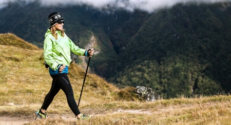 Woman hiker nordic walking in Himalaya Mountains in Nepal. Exercising in autumn natureの写真素材