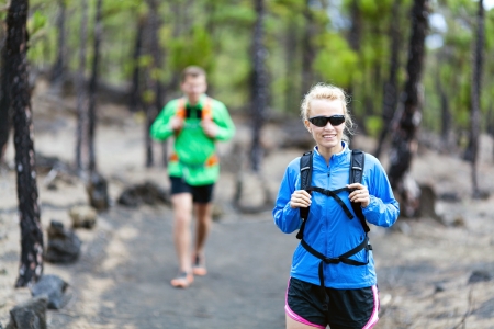 Man and woman hikers trekking on volcanic trail in mountainsの写真素材