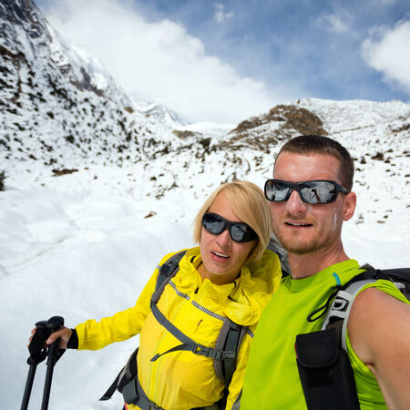 Couple hikers man and woman doing selfie portrait on expedition in winter mountains. Inspiration and motivation. beautiful nature landscape. Fitness healthy lifestyle outdoors on snow in Himalayas, Nepal, Annapurna range trekking.の写真素材