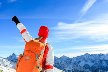 Hiking successful woman with arms outstretched, motivation inspiration in mountains. Fitness and healthy lifestyle outdoors in winter snowy beautiful natureの写真素材