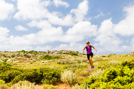 Trail running woman cross country running in inspirational mountain landscape on beautiful day. Training and working out runner jogging and exercising fitness outdoors, rocky footpath on Crete, Greeceの写真素材