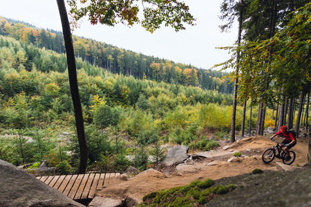 Mountain biker riding on bike in autumn inspirational mountains landscape. Man cycling MTB on enduro trail track. Sport fitness motivation and inspiration.の写真素材