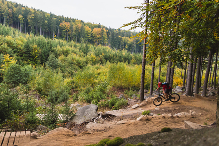 Mountain biker riding on bike in autumn inspirational mountains landscape. Man cycling MTB on enduro trail track. Sport fitness motivation and inspiration.の写真素材