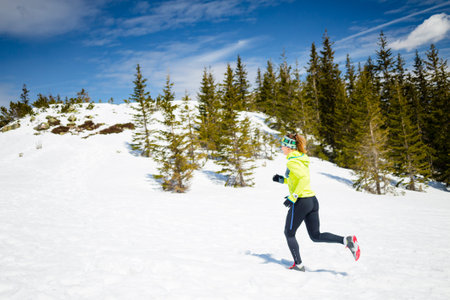 Trail running woman runner in winter mountains on snow. Motivation and inspiration fitness concept...