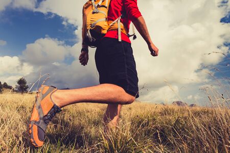 Hiking man, backpacker, climber or trail runner in mountains looking at beautiful inspirational landscape view. Fitness and healthy lifestyle outdoors in summer nature.の写真素材
