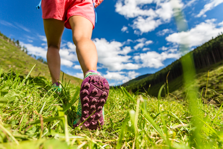 Woman walking in mountains in sport hiking shoes. Jogging, trekking or training outside in summer nature. Inspiring health and fitness concept.の写真素材