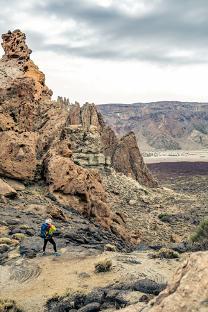 Super mom with baby boy traveling in backpack. Hiking adventure with child on autumn family trip in mountains in Tenerife, Spain.の写真素材