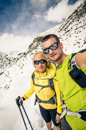 Couple hikers man and woman doing selfie portrait in winter mountains. Inspiration and motivation in beautiful landscape. Trekking and climbing partnership in Himalayas, Nepal, Annapurna Range.の写真素材
