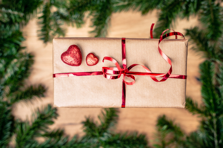 Gift or present in brown paper box with red hearts. Love concept over green background. Top view. with copy space.の写真素材